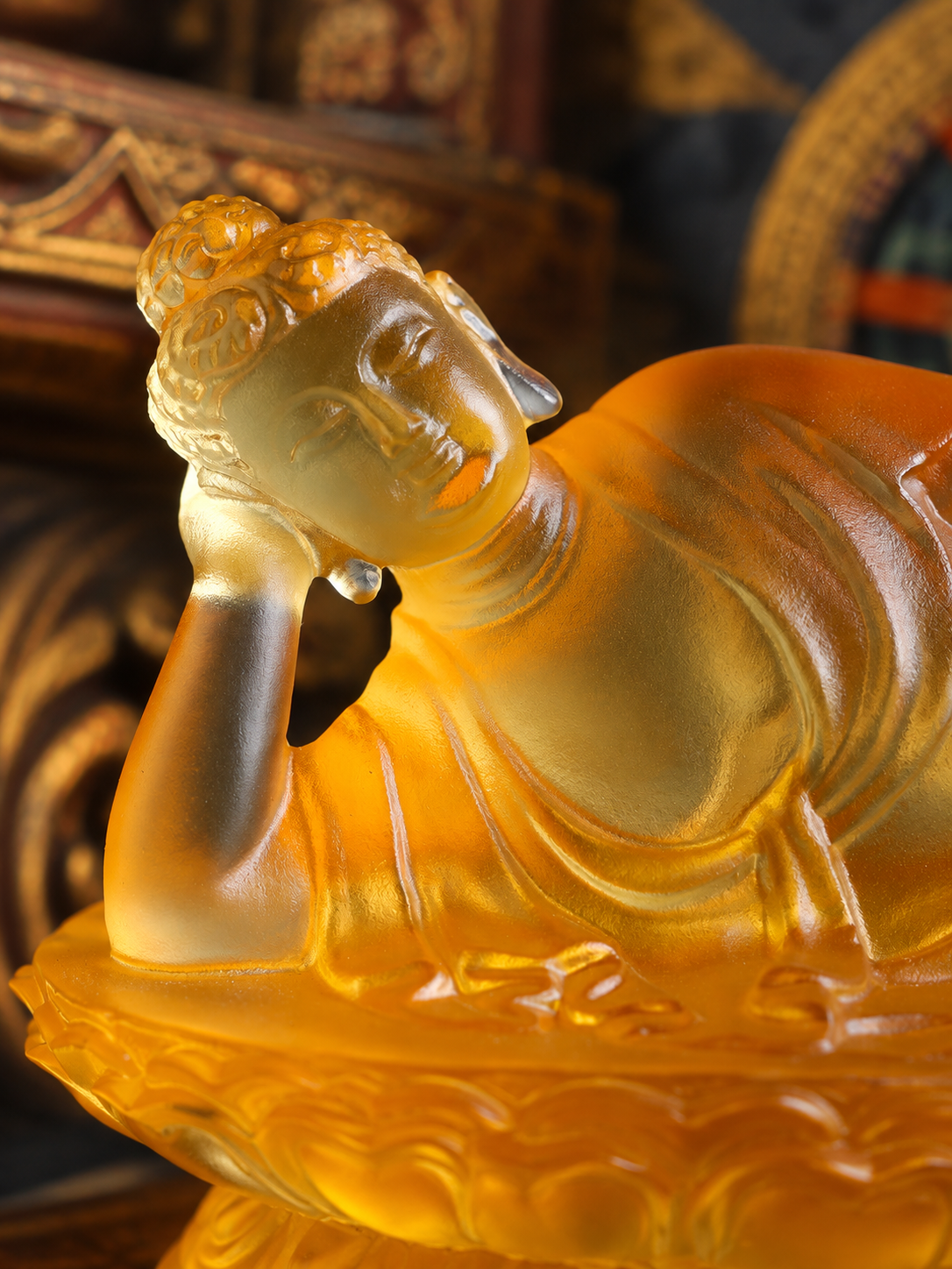 Close view of the amber-colored liuli reclining Buddha, with the head resting on one hand