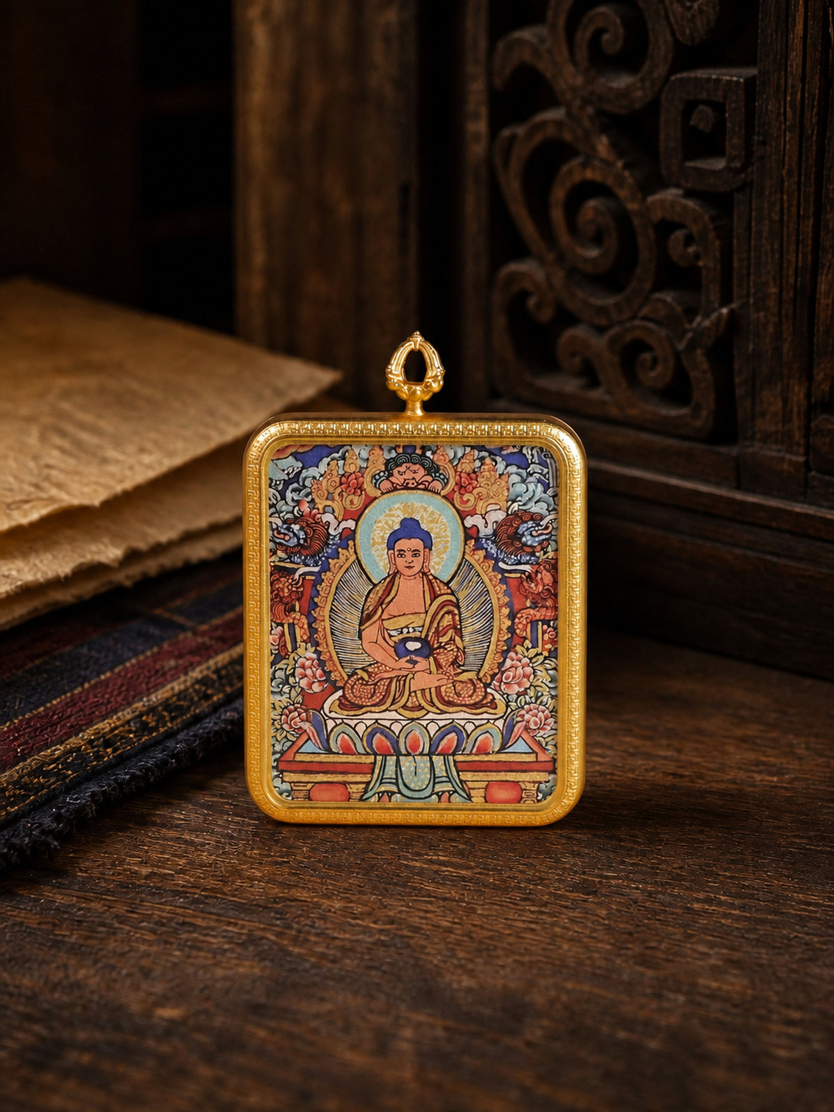 Amitabha Buddha zodiac guardian thangka pendant in a gold-colored frame, standing on dark wood
