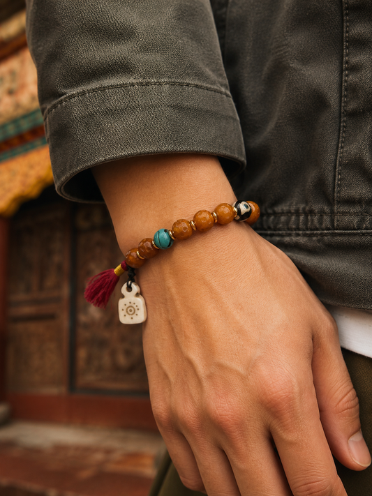 Tibetan Bone Mala Bracelet with Faceless Buddha and Three-Eye Dzi-Style Bead — worn on wrist