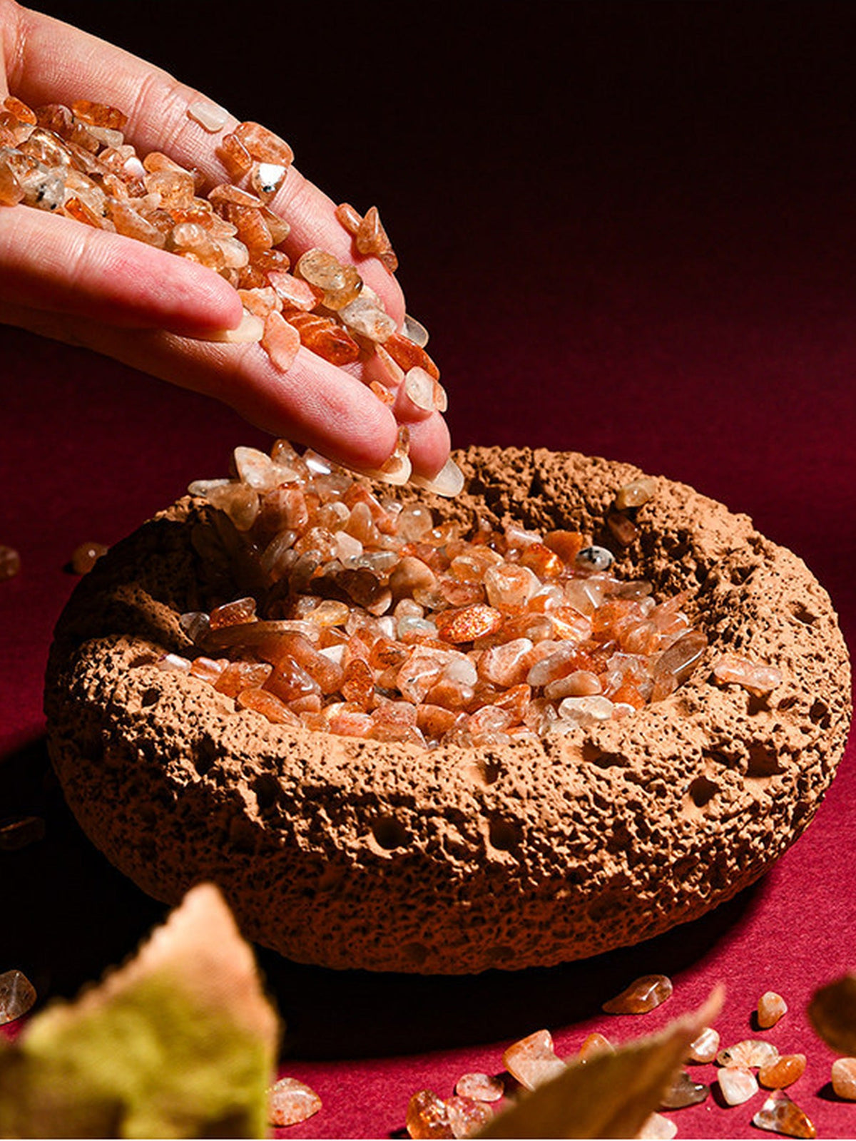 Orange cleansing bowl being filled with crystal chips