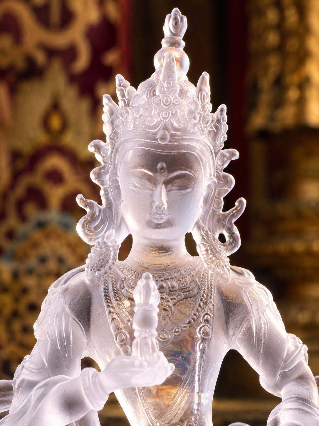 Close view of plain liuli Vajrasattva, showing the crown, face, jewelry, and raised hand