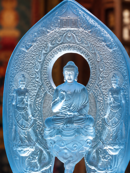 Close view of the plain Medicine Buddha triad, with the seated central figure and two smaller figures in blue glass