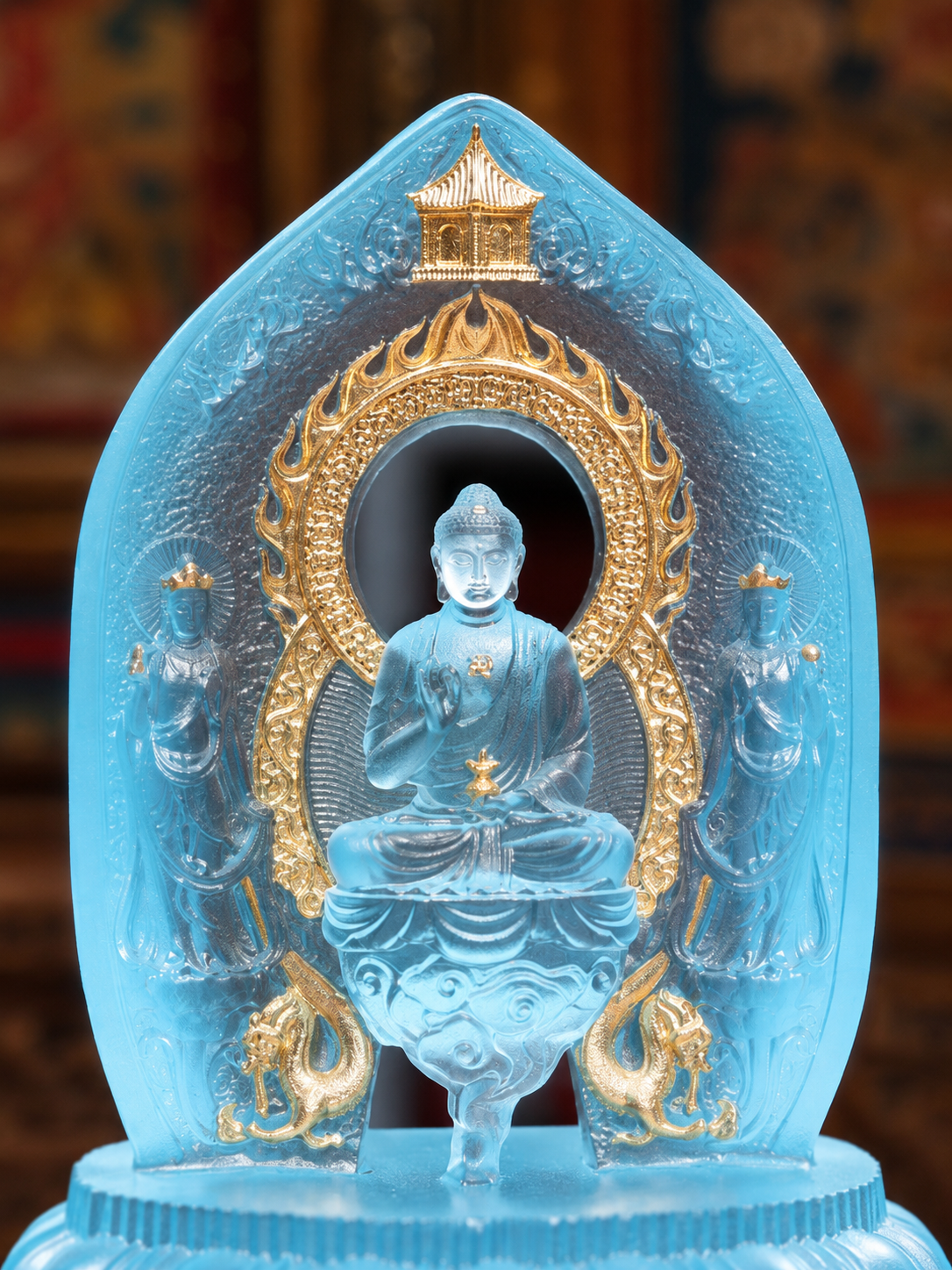 Close view of the gilded Medicine Buddha triad, showing gold-colored details around the central figure