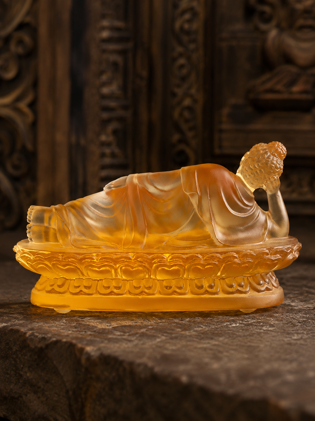 Rear side view of amber reclining Buddha statue