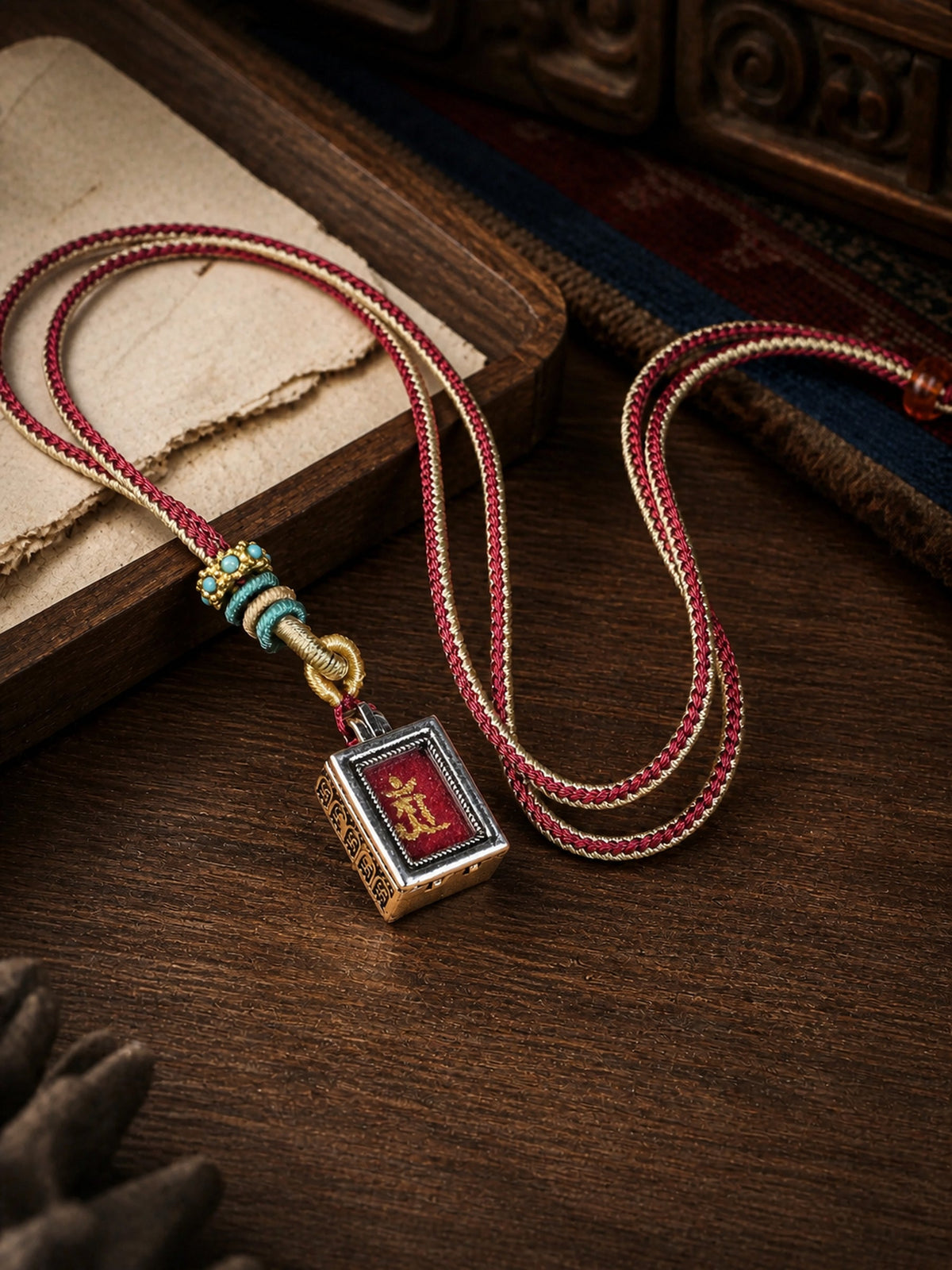 Samantabhadra Bodhisattva design mini thangka pendant: painted symbol on red, with a red-and-cream braided cord