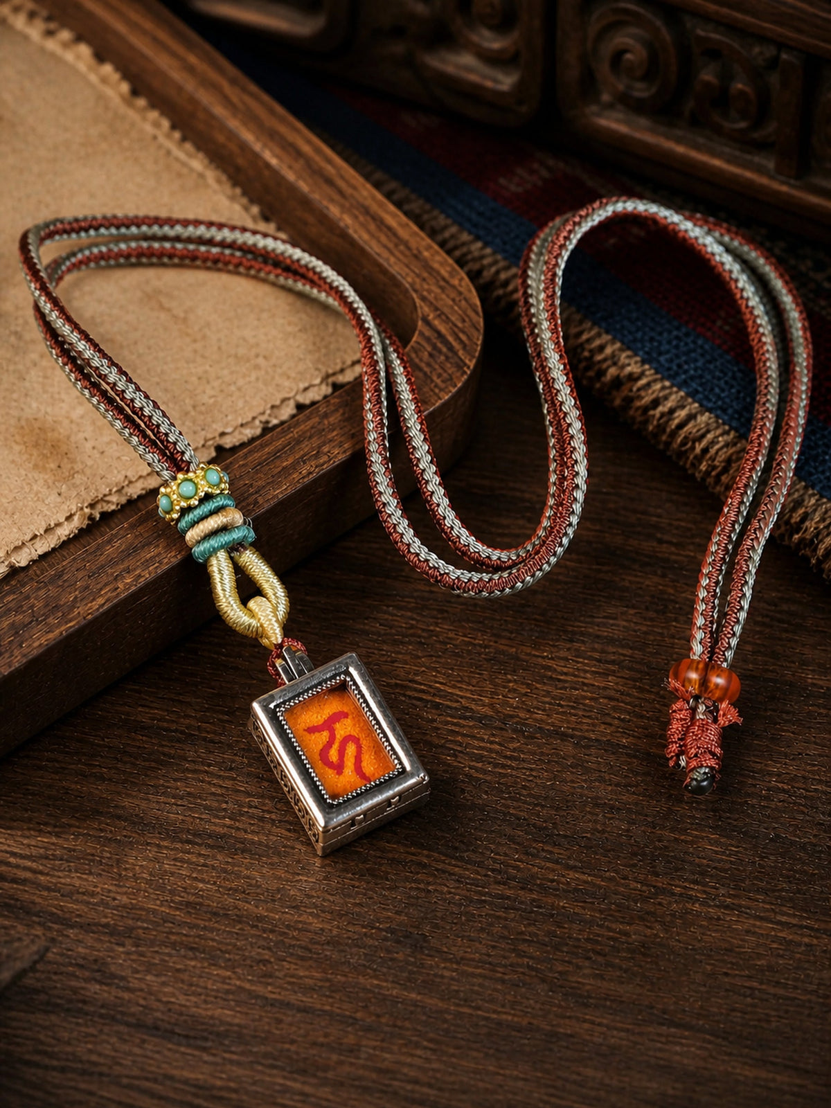 Ksitigarbha Bodhisattva design mini thangka pendant: painted symbol on orange, with a red-and-gray braided cord