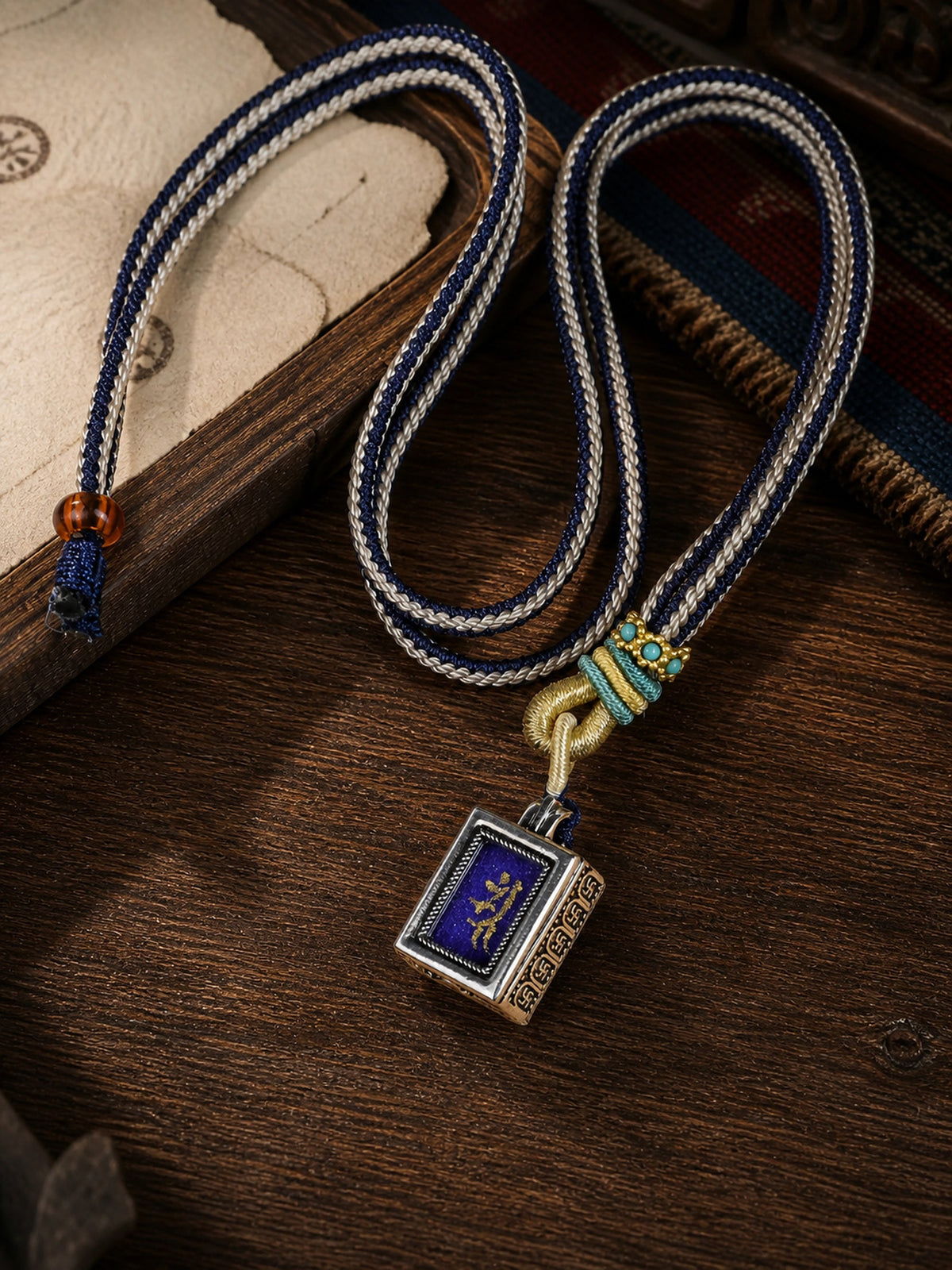 Vajrasattva design mini thangka pendant: painted symbol on purple, with a blue-and-cream braided cord