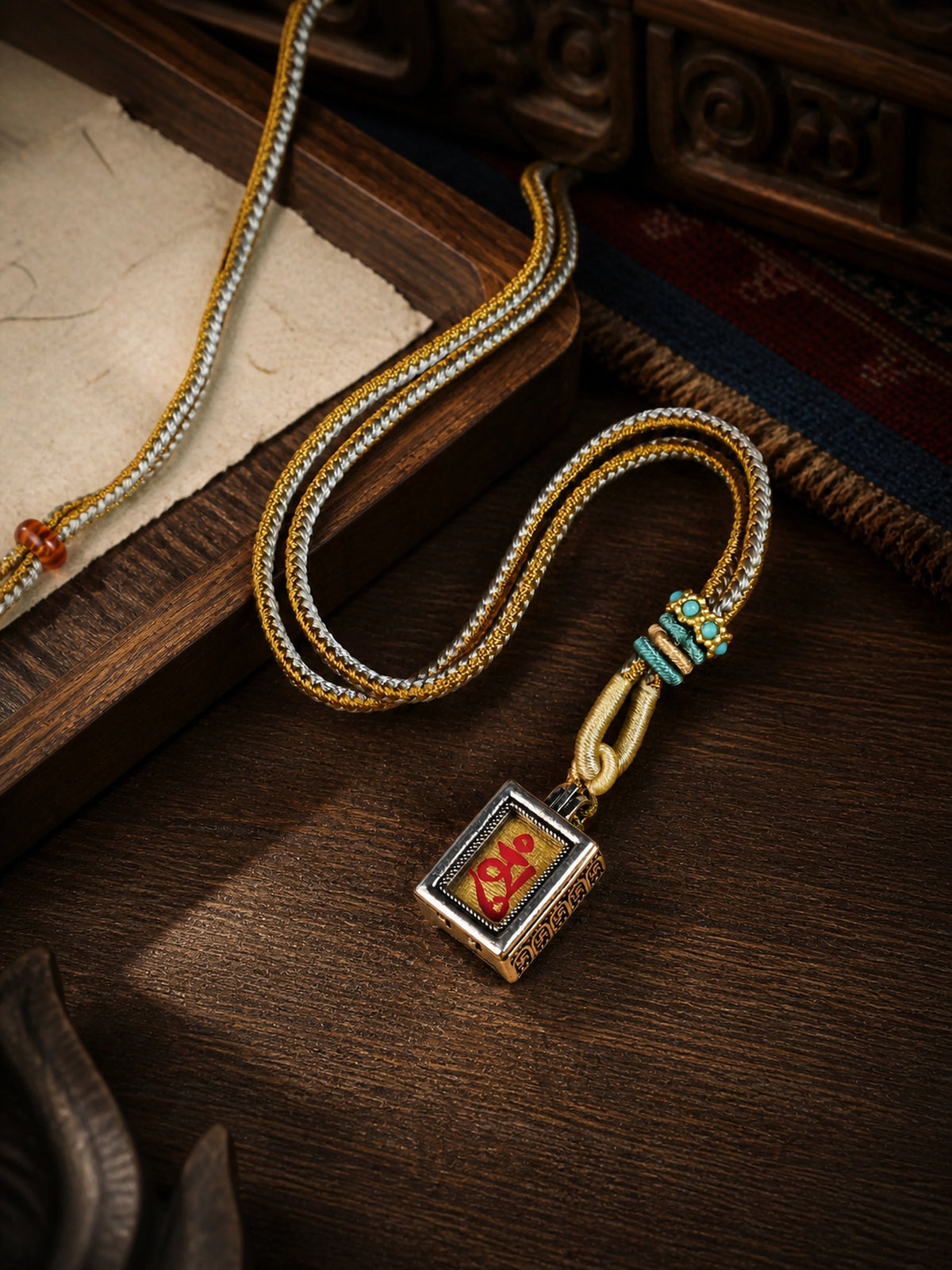 Shakyamuni Buddha design mini thangka pendant: painted symbol on pale cream, with a gold-and-gray braided cord