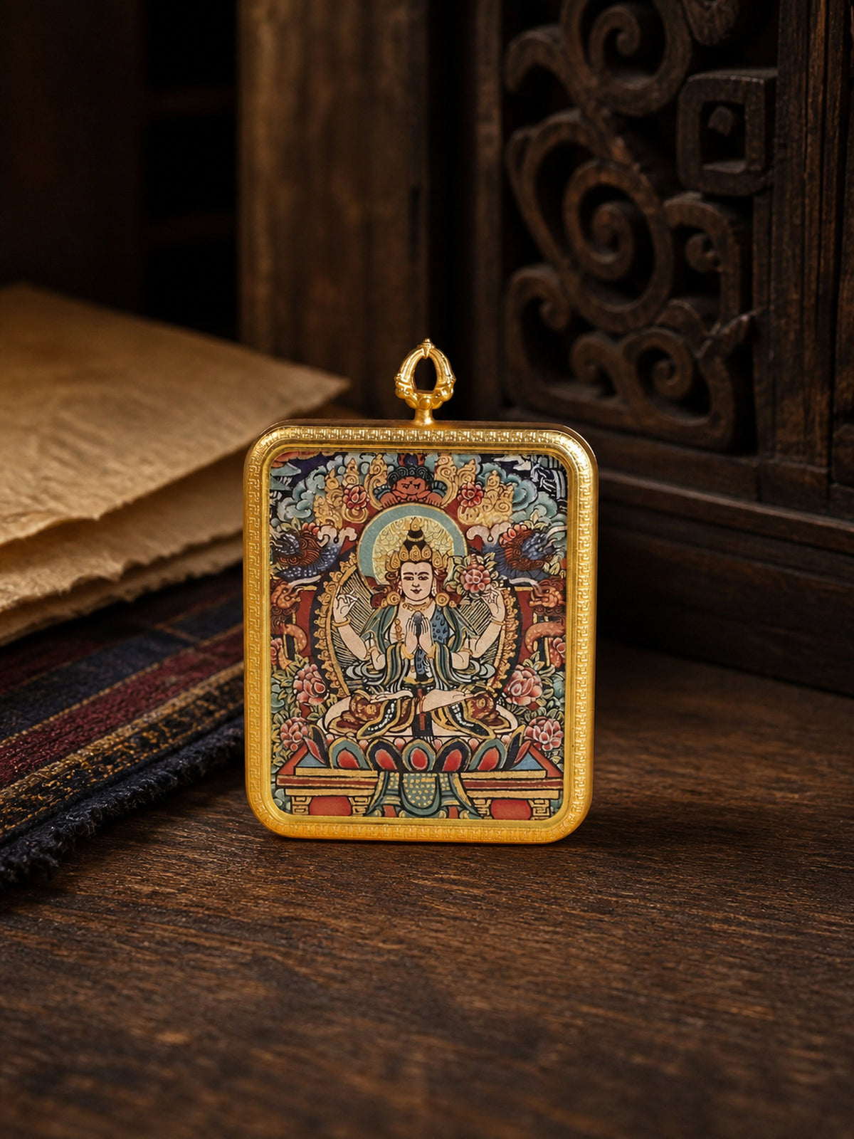 Four-Armed Avalokiteshvara zodiac guardian thangka pendant in a gold-colored frame, standing on dark wood
