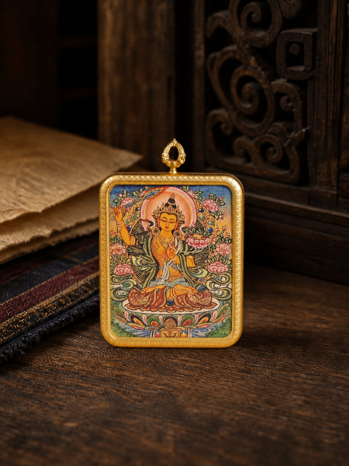 Manjushri Bodhisattva zodiac guardian thangka pendant in a gold-colored frame, standing on dark wood