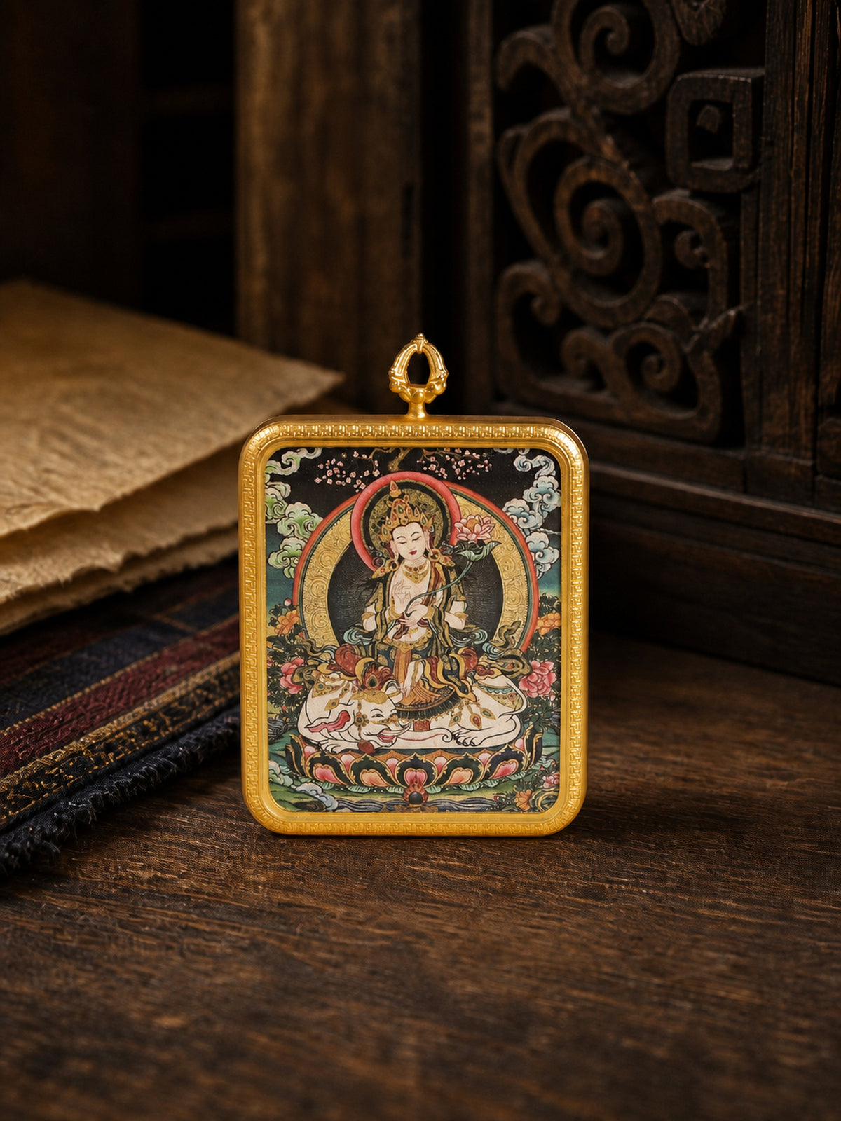 Samantabhadra Bodhisattva zodiac guardian thangka pendant in a gold-colored frame, standing on dark wood