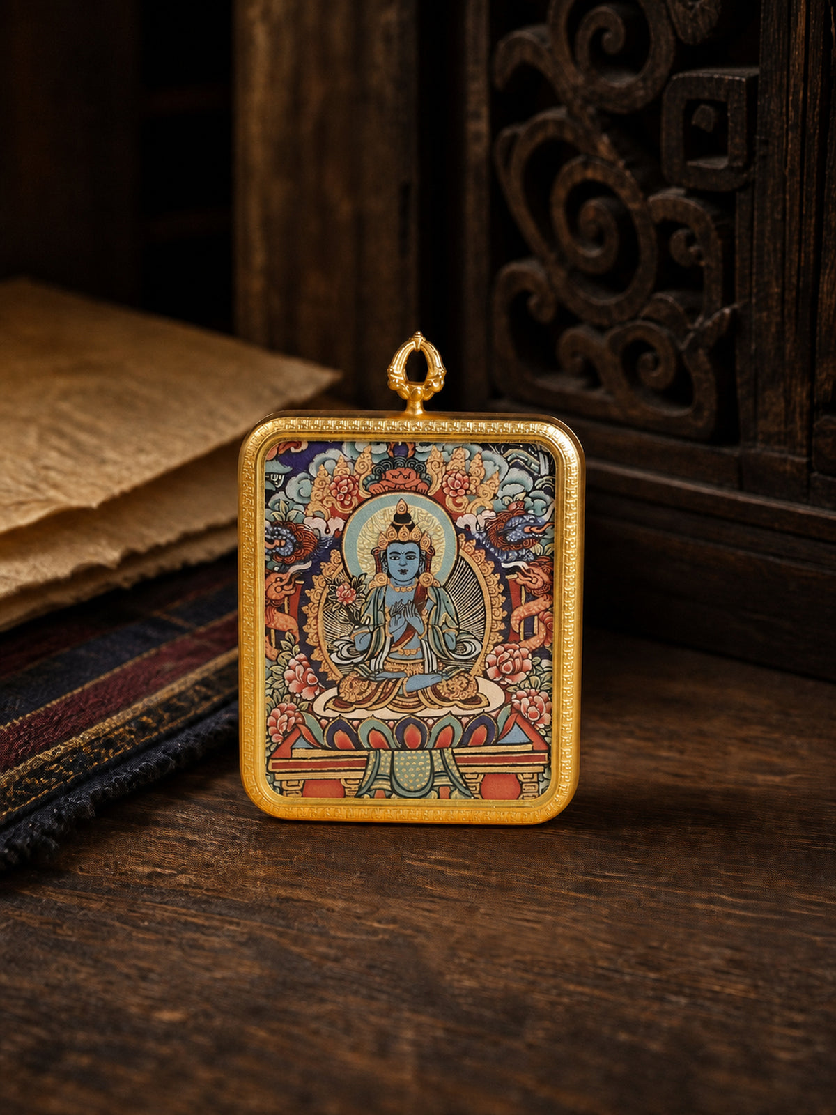 Mahasthamaprapta Bodhisattva zodiac guardian thangka pendant in a gold-colored frame, standing on dark wood