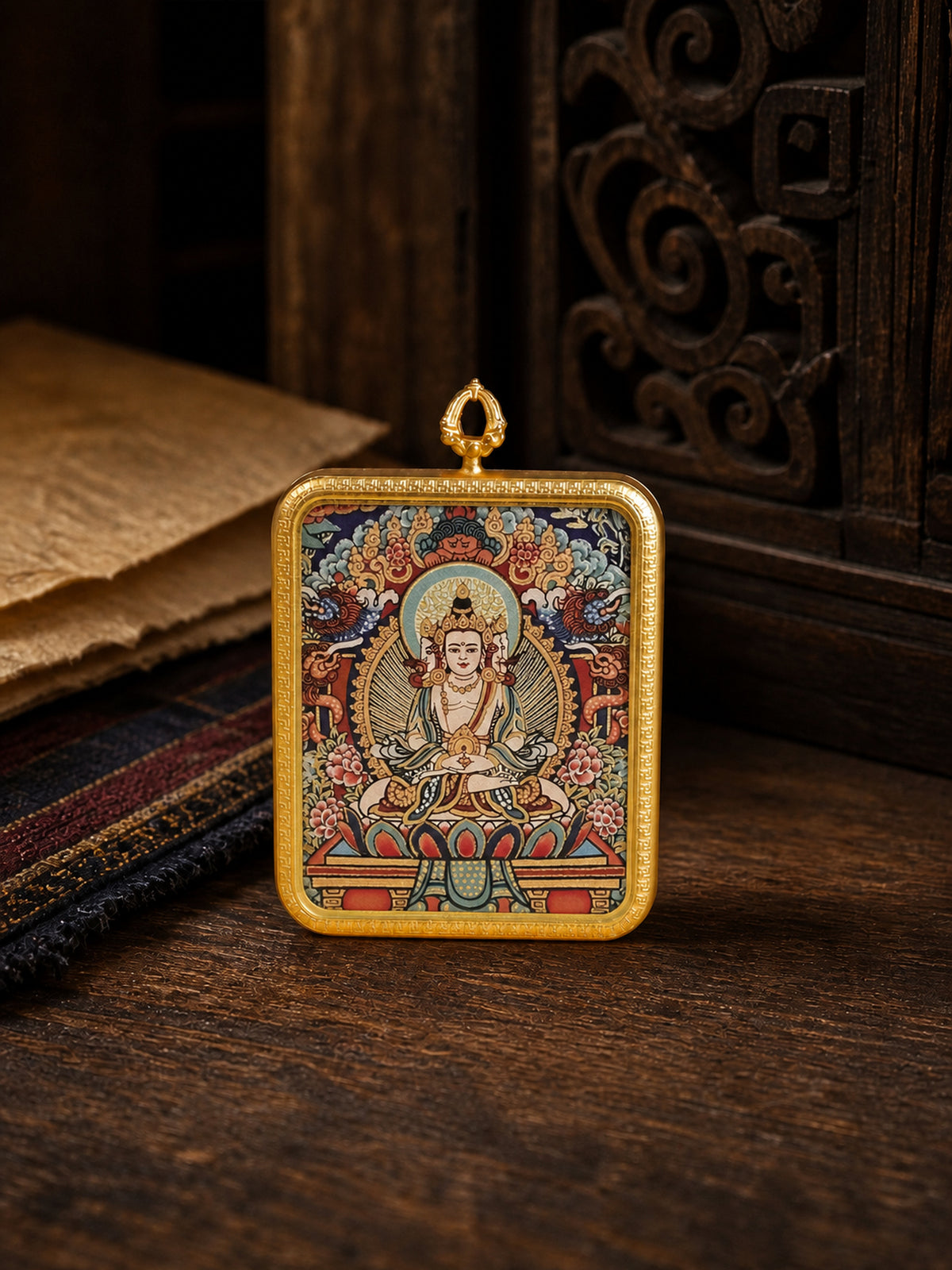 Vairocana Buddha zodiac guardian thangka pendant in a gold-colored frame, standing on dark wood