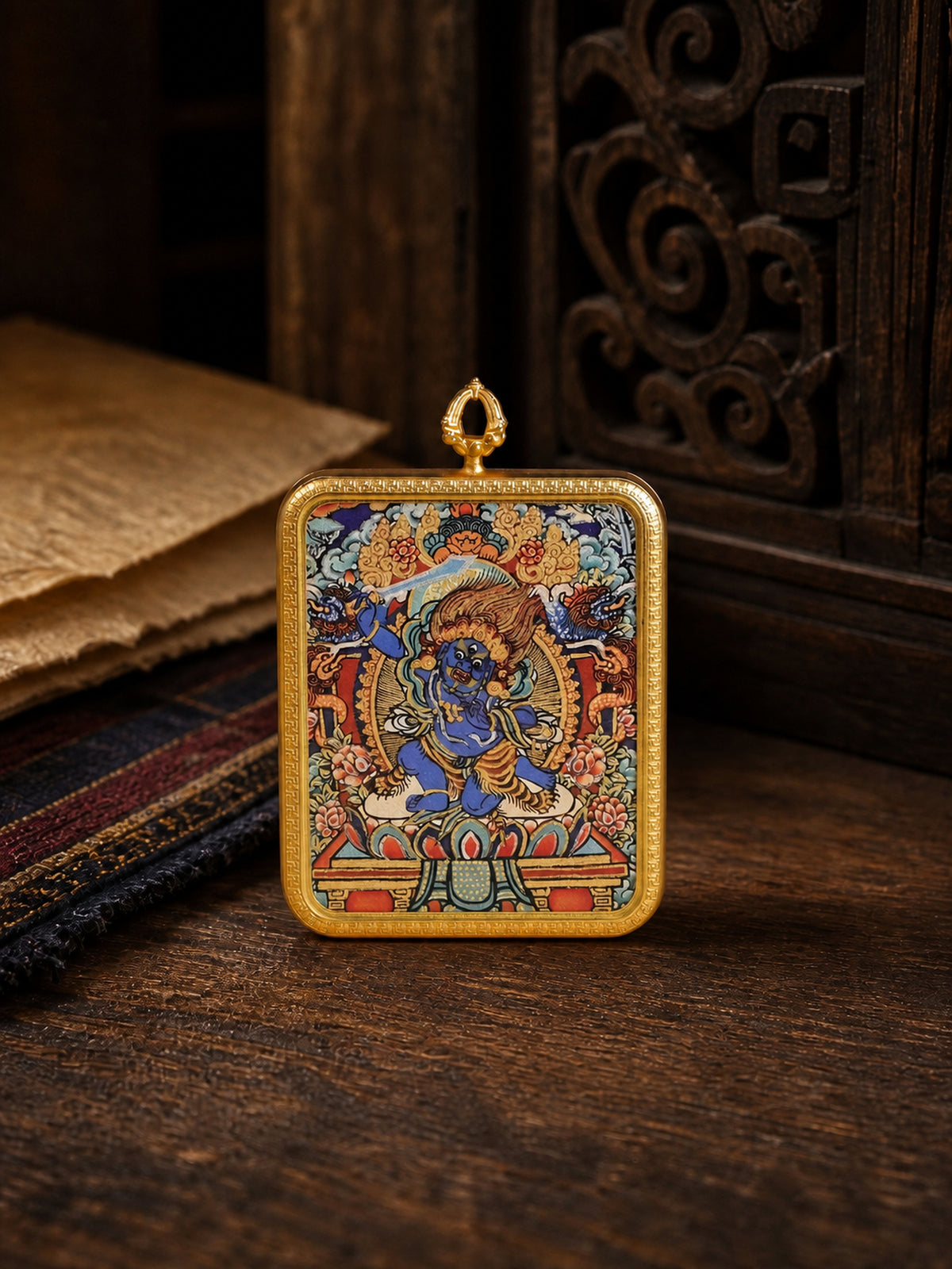 Acala zodiac guardian thangka pendant in a gold-colored frame, standing on dark wood