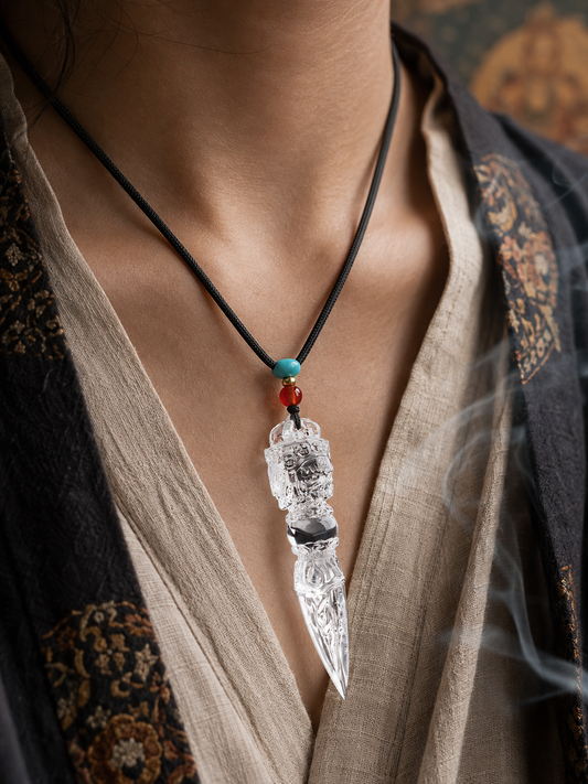 Clear quartz vajra amulet worn at the chest