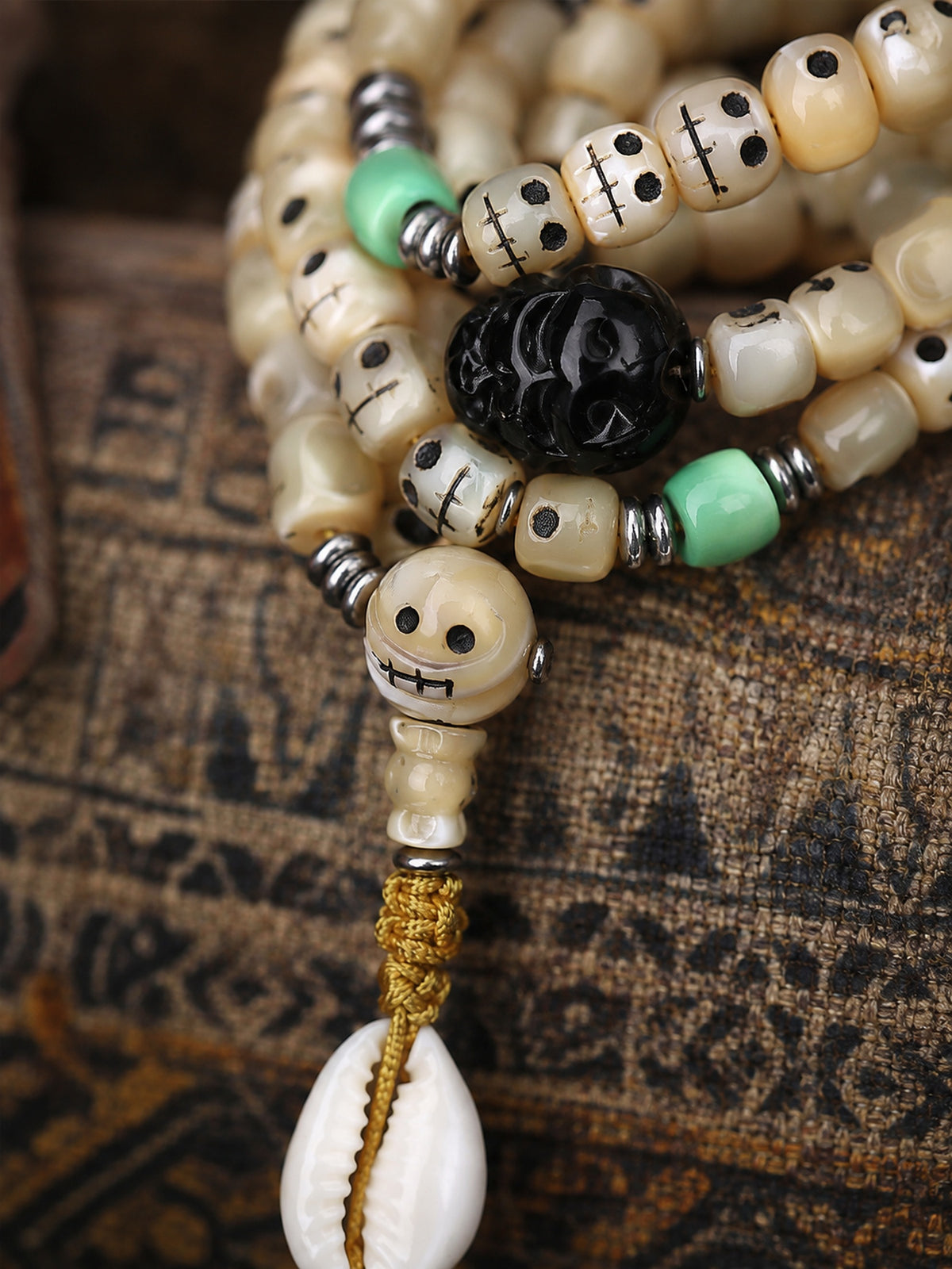 108-Bead Fish Bone Mala with Carved Skull and Shell Accents — detail view 1