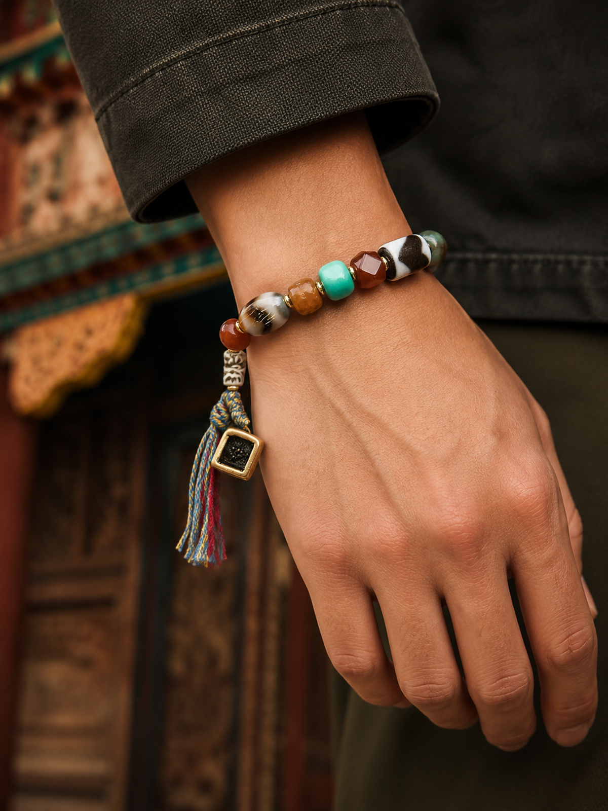 Tibetan Multigem Mala Bracelet with Yellow Jambhala Gau Charm — worn on wrist