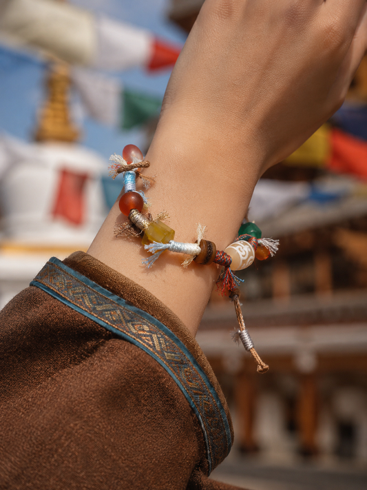Tibetan treasure-vase Dzi-inspired handwoven cord bracelet worn on wrist