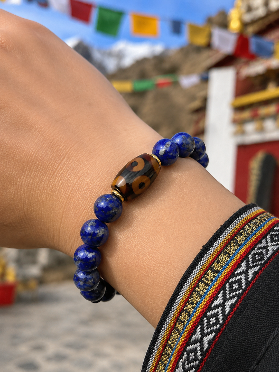 Royal blue lapis lazuli lotus three-eye Dzi-inspired bracelet worn on wrist