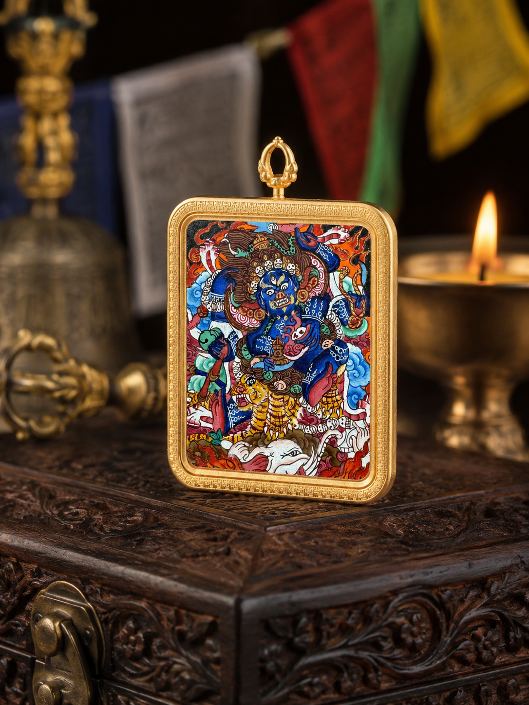 Front view of the painted Mahakala pendant on a carved wooden box