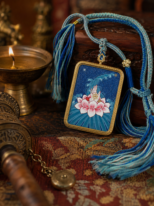 Lotus thangka pendant with a pink flower on blue, displayed with a blue tasseled cord