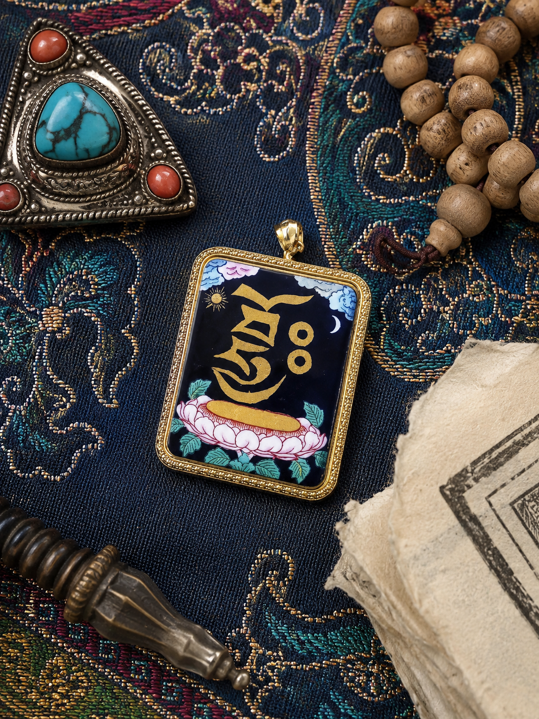 Close view of the Zaki Lhamo Heart Mantra pendant on blue patterned fabric