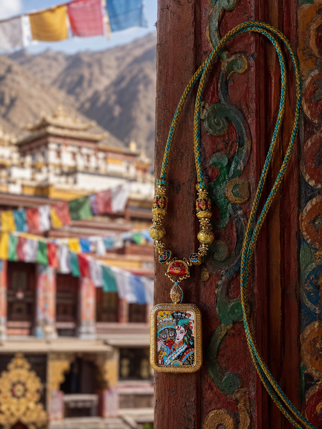 Zaki Lhamo pendant hanging beside a painted post on a green-and-gold cord