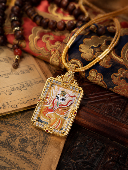 Fox Immortal pendant and golden cord laid beside printed pages and patterned fabric
