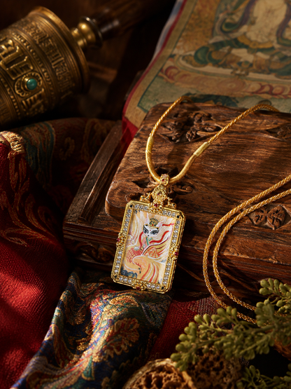 Fox Immortal pendant resting against a carved wooden box with its golden cord beside it