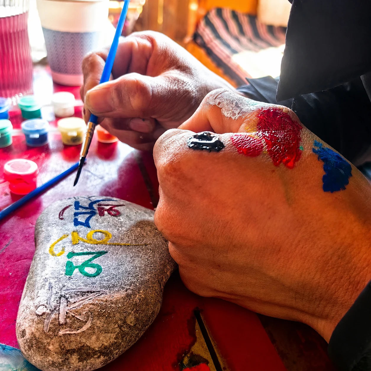 An artisan painting a sacred symbol by hand